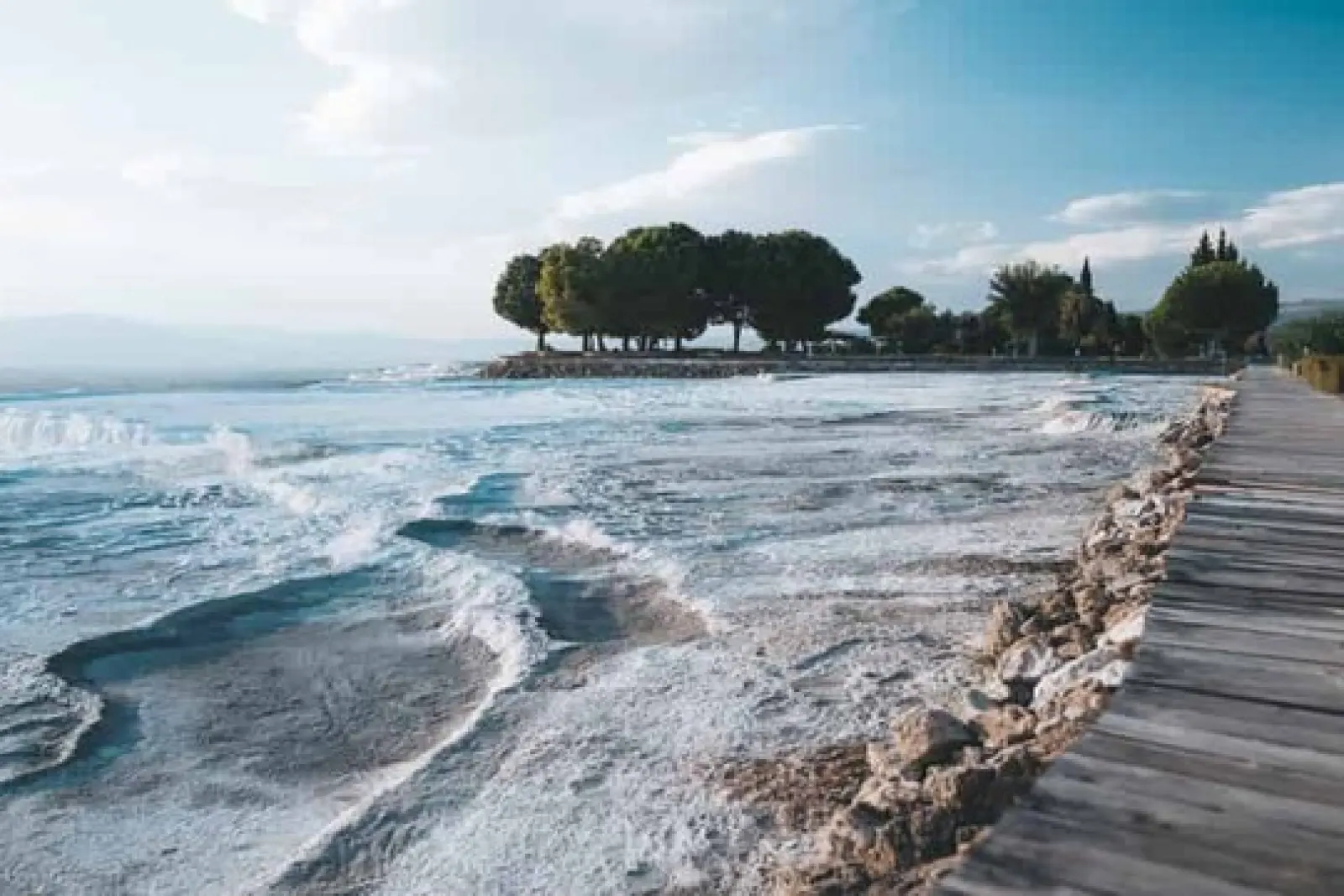 terrazas naturales de travertino con agua termal y pasarela de madera en Pamukkale