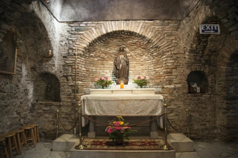 Altar con estatua religiosa en una pequeña capilla de muros de ladrillo y piedra antigua