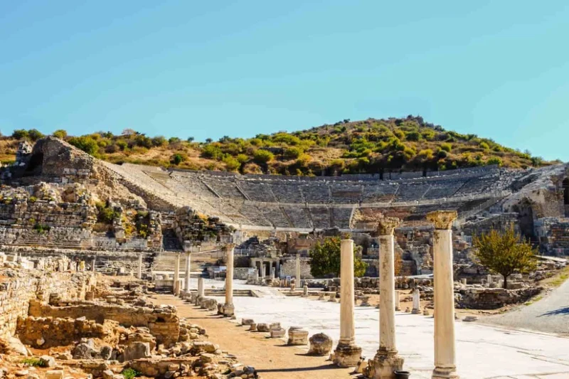 restos arqueológicos del teatro antiguo en el sitio histórico de Éfeso con un cerro al fondo