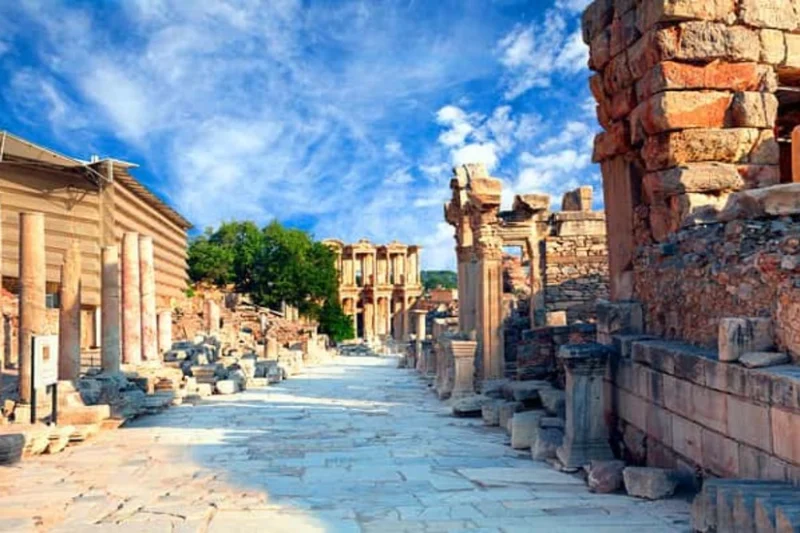 Calle principal de mármol con ruinas antiguas y la fachada de la Biblioteca de Celso al fondo en Éfeso.