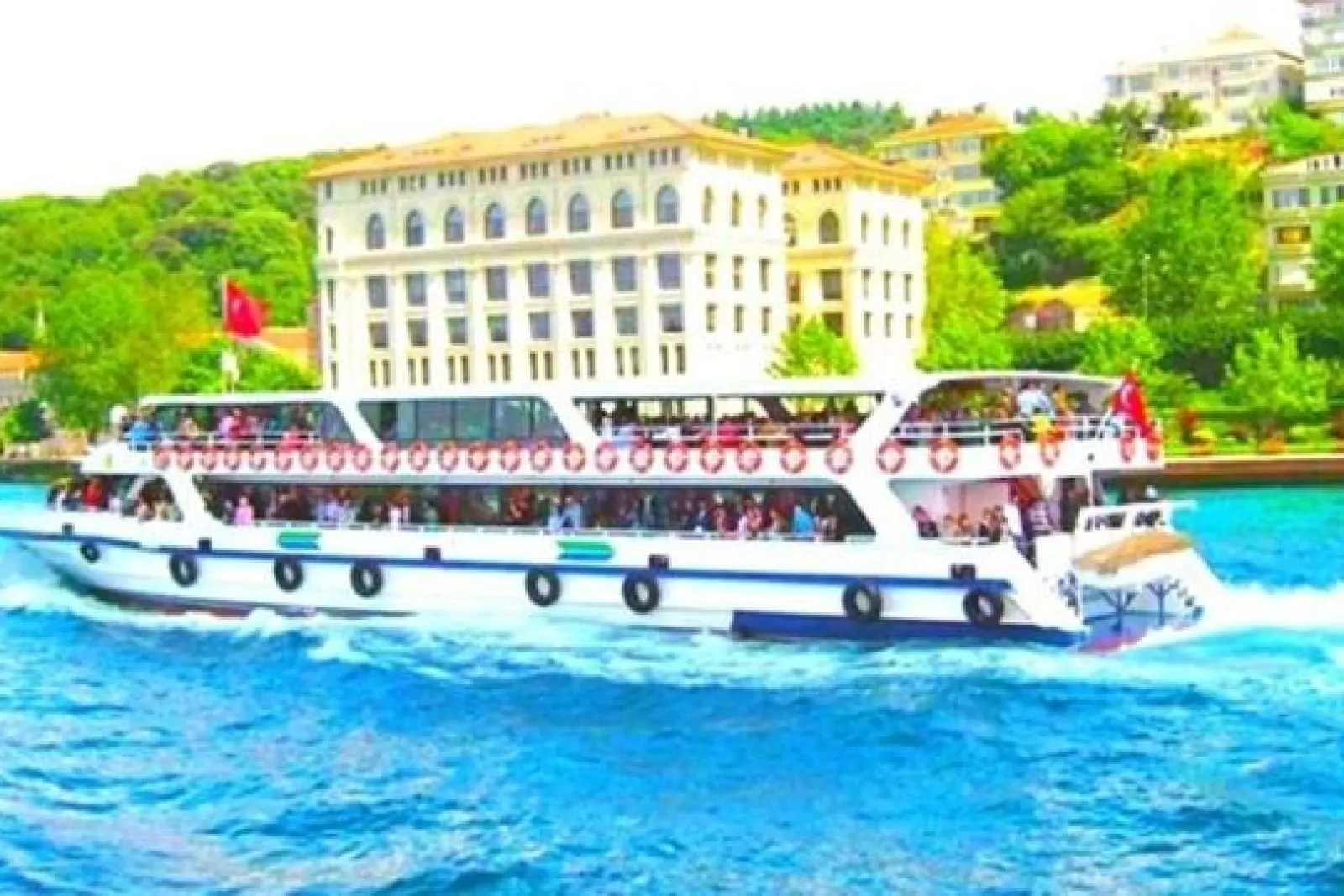 Barco turístico navegando por el Bósforo frente a edificios y vegetación urbana de Estambul.