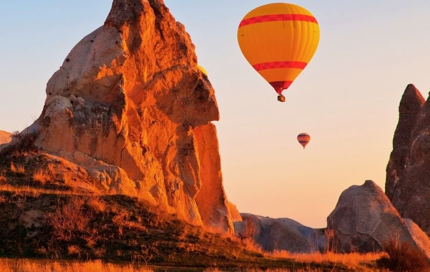 Globo aerostático sobre formaciones rocosas al amanecer en Capadocia